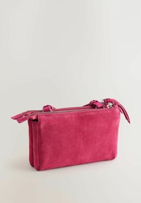 Bolso rectangular de ante rosa con cierre de cremallera, que cuenta con dos compartimentos con cremallera y una textura suave. El diseño incluye un hardware minimalista.