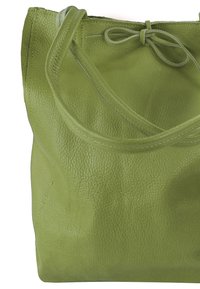 Groene leren totebag met een gladde textuur, dubbele handvatten en een gestrikte sluiting. Licht slouchy ontwerp met zichtbare stikdetails.