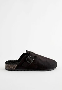 Crne suede slip-on klompe s mekim unutrašnjim dijelom, s remenom i kopčanjem. Potplat ima točkasti dizajn, što poboljšava prianjanje.