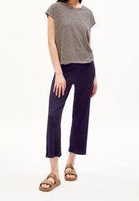 Pruhovaný krátký rukáv top v černé a bílé barvě, spárovaný s námořnickými zkrácenými kalhotami a hnědými sandály. Měkká tkanina s uvolněným střihem.