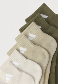 Τέσσερα ζευγάρια κάλτσες σε αποχρώσεις του πράσινου και του μπεζ, με ριμπ μανσέτες και λευκό μοτίβο λογότυπου κοντά στον αστράγαλο. Μαλακό πλεκτό υλικό.