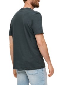 Donkergrijze katoenen t-shirt met korte mouwen, ronde hals en een relaxte pasvorm, met een zoom die onder de taille valt en minimale stikseldetails.