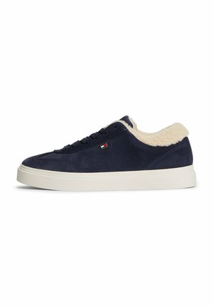 Navyblaue Wildleder-Sneaker mit weißem Fleecefutter, weißer Gummisohle, schwarzen Schnürsenkeln und kleinem rechteckigem Logo an der Seite.