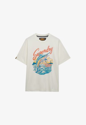 Wit T-shirt met de tekst "Superdry", een springende marlijn boven oceaangolven, en "Atlantic Coast" in zonsondergangkleuren.