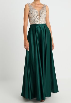 Mouwloze jurk met een champagnekleurig lijfje bedekt met pailletten en een donkergroene satijnen rok tot op de grond, voorzien van een V-halslijn en een getailleerde taille.