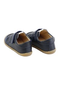 Zapatos infantiles de cuero en color marino con correas de Velcro, cuello acolchado y suelas de goma. Presentan costuras en contraste y una textura suave.