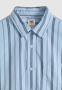 Chemise bleu clair à boutons avec rayures noires verticales, col pointu et poche poitrine, taille moyenne, marque Levi's.