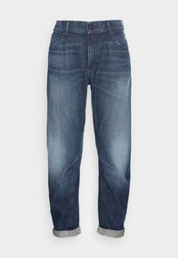 Tmavě modré vybledlé džíny s ohrnutými manžetami, předním knoflíkem a designem s pěti kapsami, vystavené na bílém pozadí.