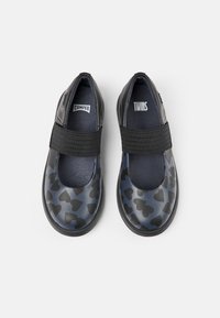 Zwarte platte schoenen met een hartpatroon, elastische band over de middenvoet en een rond neusontwerp. Zachte, glanzende afwerking met een donkere zool.