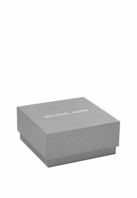 Caja de cartón plateada con una superficie texturizada, con un logo blanco "MICHAEL KORS" en la parte superior, de forma cuadrada y con un diseño de tapa.