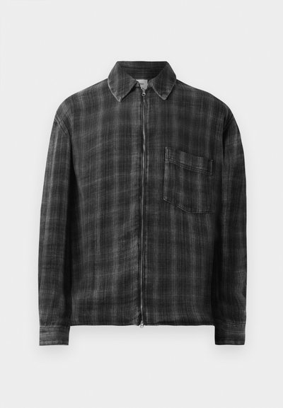 Chaqueta con cierre de cremallera en cuadro negro y gris, con cuello, mangas largas y un bolsillo en el pecho. Fabricada con un tejido texturizado. Detalle de cremallera suave.