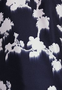 Námořnická látka s bílým vzorem připomínajícím mraky. Design obsahuje jemné přechody a texturální variace, což vytváří dynamický vizuální efekt.