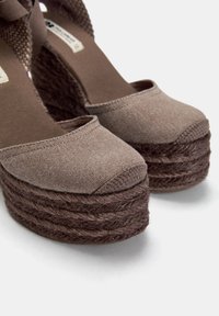 Wedge espadrilles in tela marrone con piattaforma in juta intrecciata. Punta arrotondata, dettagli in corda spessa sulla suola e una texture morbida.