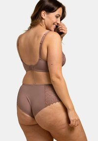 Ensemble soutien-gorge et culotte en mauve. Le soutien-gorge dispose de bretelles réglables et d accents en dentelle. La culotte possède des panneaux latéraux en dentelle et un bord festonné. Texture douce.