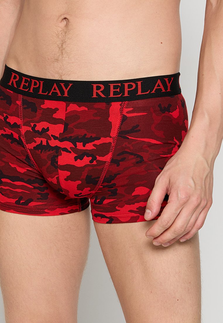 Rote und schwarze Camouflage-Boxershorts mit einem schwarzen Taillenbund, der mit roten "REPLAY"-Schriftzügen versehen ist, und aus einem weichen, dehnbaren Material für Komfort.