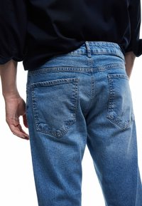 Lichtblauwe, vervaagde denim jeans met een klassiek vijf-pocket ontwerp. De achterkant toont twee achterzakken en een reguliere tailleband.