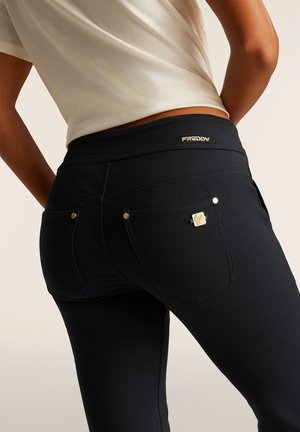 Pantaloni elasticizzati neri con un alto punto vita, caratterizzati da cuciture decorative, due tasche posteriori e un piccolo accento in metallo con logo.
