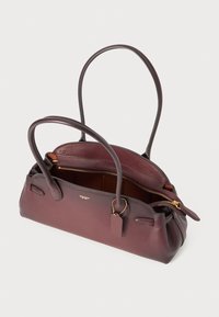 Borsa a tracolla in pelle borgogna con manici doppi, chiusura con zip e un'etichetta discreta. L'interno presenta una texture liscia e un colore chiaro a contrasto.
