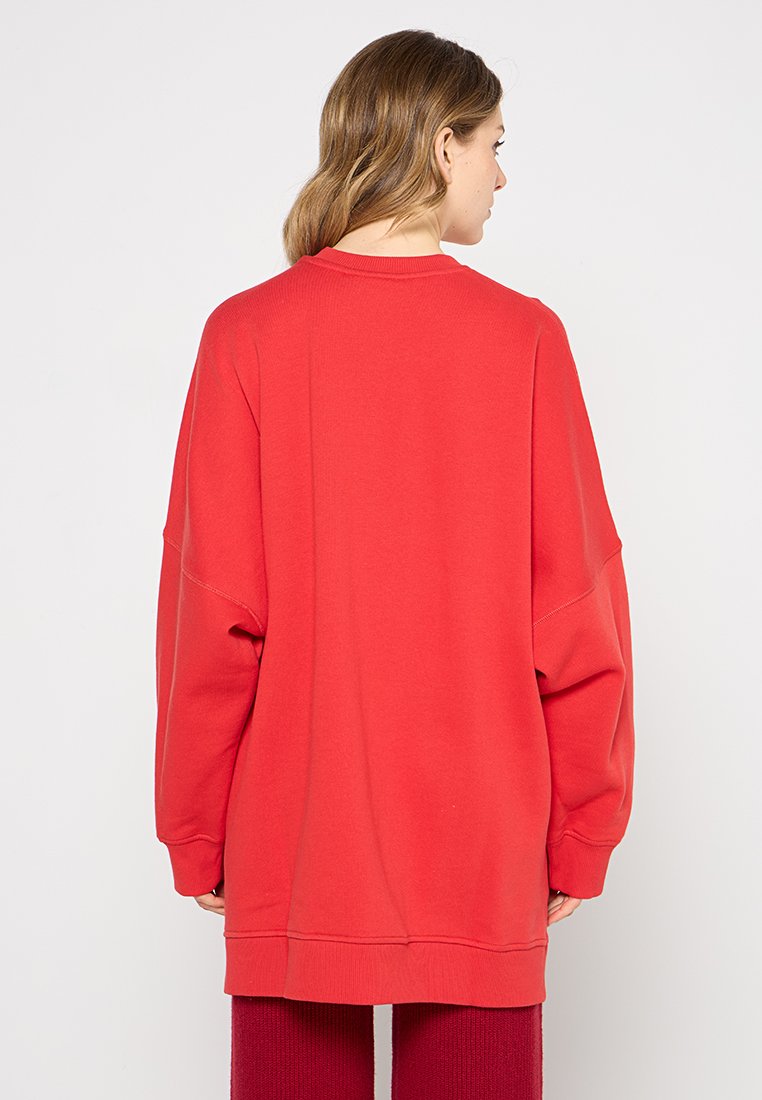 Czerwona, oversize bluza z okrągłym dekoltem, opuszczonymi ramionami oraz ściągaczami przy rękawach i u dołu. Wykonana z miękkiej mieszanki bawełny o gładkiej fakturze.
