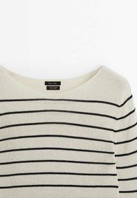 Maglione di cotone con scollatura ampia e righe orizzontali nere su uno sfondo color crema; tessuto lavorato a maglia con etichetta visibile.
