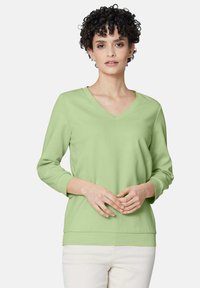 Lichtgroene V-hals sweatshirt met lange mouwen en geribde manchetten, met een relaxte pasvorm en een zachte, gladde stoftextuur.