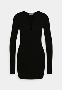 Svart stickad klänning med lång ärm, rund halsringning och snörningsdetalj vid bröstet. Enkel, figurnära design med ribbad textur.