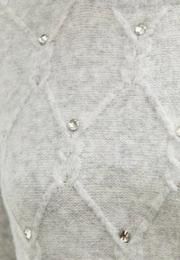 Lichtgrijze gebreide trui met een ruitpatroon, zachte textuur en decoratieve heldere rhinestones die het oppervlak sieren.