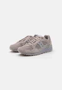 Light gray suede and mesh sneaker with laces, padded collar, and rubber sole featuring textured accents and logo detail on the side.