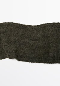 Écharpe en laine tricotée vert foncé, surface texturée, bords irréguliers, offrant une sensation douce et duveteuse. Convient pour la chaleur et le confort.