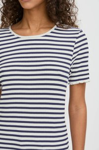 Stribet t-shirt i marineblå og hvid, ribbet tekstur, rund halsudskæring, korte ærmer med bølgede kanter. Tætsiddende design.