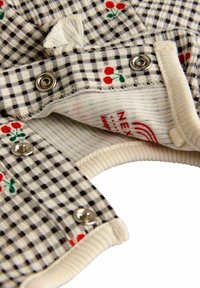 Juoda ir balta ginkhan medžiaga su raudonų vyšnių raštu, su spaudimo užtrauktukais, banguota apykakle ir minkšta tekstūra. Matomi etiketės viduje.