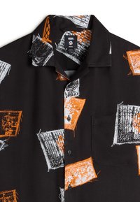 Black short-sleeve shirt with orange and white abstract patterns, featuring a chest pocket and a button-down collar. Fabric appears smooth.