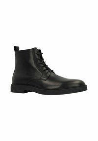 Bottine en cuir noir avec finition texturée, fermeture lacée à l'avant, bout rond et semelle en caoutchouc basse. Équipée d'une sangle à l'arrière pour un enfilage facile.