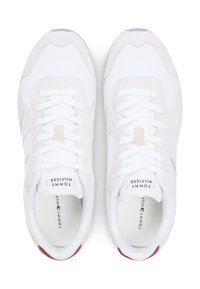 Λευκά αθλητικά παπούτσια με πλέγμα και σουέντ υλικά, στρογγυλή μύτη, επενδυμένη γλώσσα, επίπεδα λευκά κορδόνια και μικρή κόκκινη λεπτομέρεια στη φτέρνα.