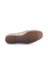 Beige platte schoen met een bovenwerk van soepel leer, flexibele bruine rubberen zool en subtiele patroonaccenten op de teentip. Merknamen "Gabor" is erin gedrukt.
