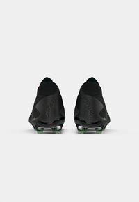 Black soccer cleats with a textured synthetic upper, featuring a sleek design, distinct logo, and green-tipped studs for traction.