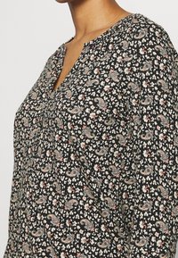 Schwarzes Stoffhemd mit V-Ausschnitt, kleinen floralen und Paisleymustern in Creme und Pink, mit einer weichen Textur und lässigem Schnitt.