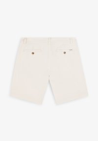 Shorts bej din bumbac, cu două buzunare la spate cu închidere prin buton și un eticheta de marcă pe talie. Textură netedă.