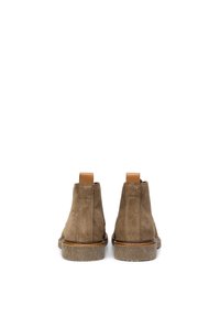 Bottines en daim marron avec des languettes en cuir beige, des détails texturés et des semelles en caoutchouc légères. Design simple avec des accents de couture subtils.