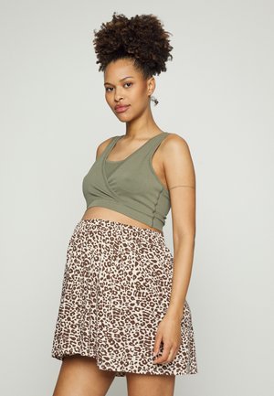 Top de tanque curto verde-oliva com um design drapeado, combinado com uma saia bege com um padrão de estampa de leopardo castanho, de textura suave.