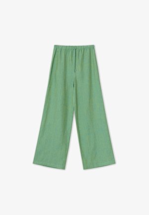 Pantaloni ampi verde chiaro realizzati in un tessuto testurizzato. Presentano un bordo elasticizzato con cordino e senza motivi visibili.