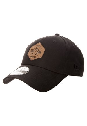 Czarna czapka z daszkiem z brązową sześciokątną łatą z napisem "Buffalo New Era Since 1920" i zakrzywionym rondem z srebrną naklejką.