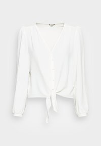 Blouse blanche à manches longues avec décolleté en V, boutons recouverts de tissu sur le devant, et nœud noué à l'ourlet.