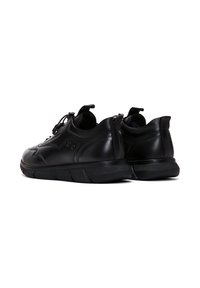 Sneakers in pelle nera con forma arrotondata, superficie testurizzata, lacci elastici e collo imbottito. Presentano una suola in gomma spessa per un supporto ottimale.