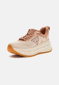 Heledatbese sneaker pruunide detailidega, millel on võrkpinna ülemine osa, tekstureeritud tallad oranži kummiga ja silmapaistvad logo detailid küljel.