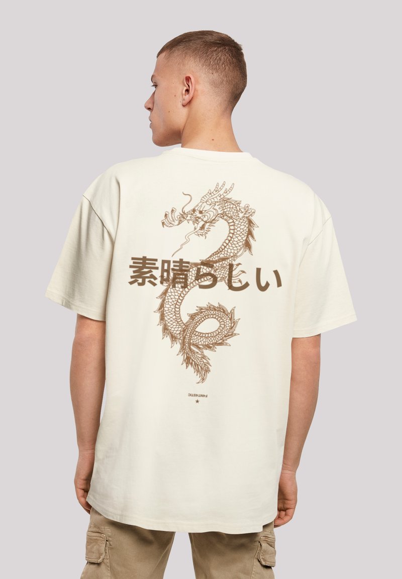 Beige cotton t-shirt featuring a large brown dragon graphic and Japanese text on the back. Short sleeves and relaxed fit.