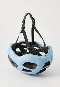 Casque de vélo bleu clair avec des sangles noires, doté de trous de ventilation et d'étiquettes de sécurité, reposant sur un fond blanc uni.