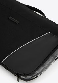 Schwarze Laptoptasche aus strukturiertem Stoff mit einem glatten, glänzenden Akzent. Verfügt über einen silbernen Reißverschluss und ein schwarzes Logo-Label.