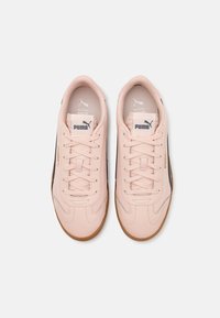 Vaaleanpunaiset lenkkarit, joissa on sileä synteettinen yläosa, samanväriset nauhat ja puu-rubberpohjat. Varustettu mustalla sivuviivalla ja logotunnuksilla.