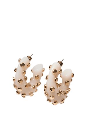 Orecchini a cerchio color crema con borchie dorate arrotondate distribuite uniformemente sulla superficie, dotati di perni metallici per orecchie trafitte.